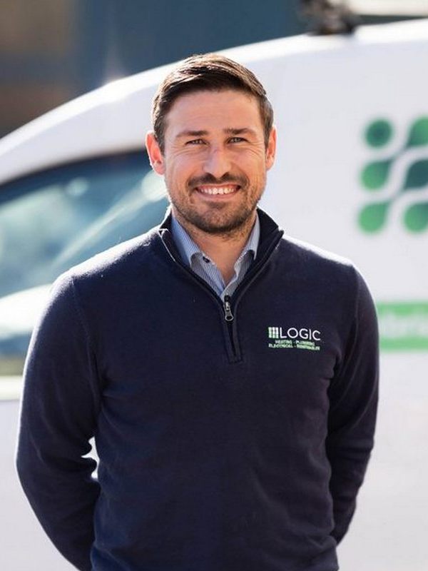 Man standing in front of a Logic Plumbing Electrical and Heating van